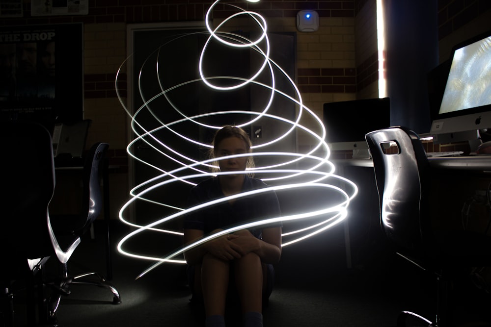 a woman sitting in front of a computer screen