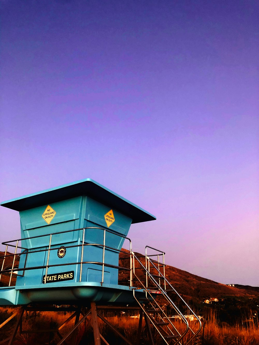 a blue lifeguard tower sitting on top of a beach