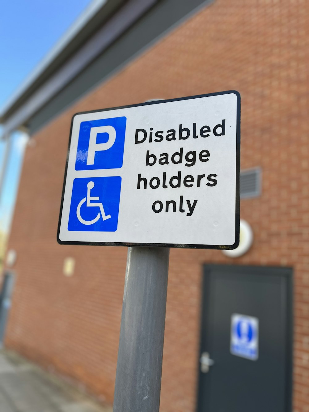 a handicapped badge on a pole in front of a building