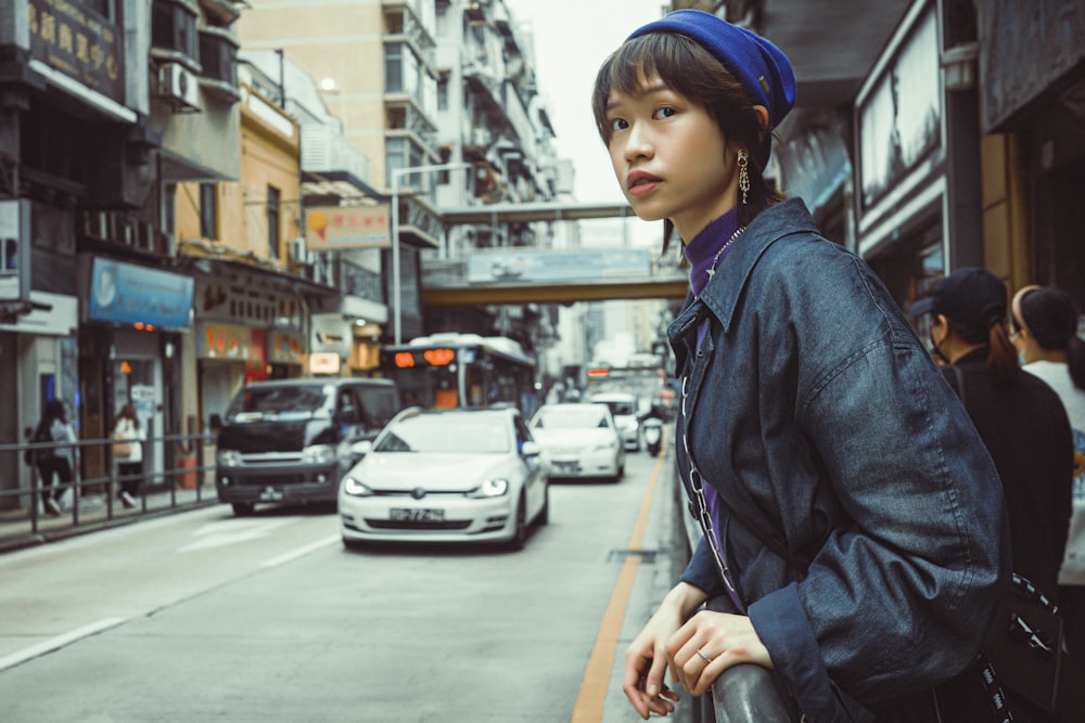 a woman standing on the side of a street