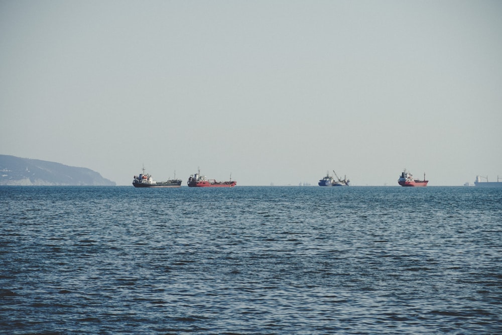 Un grupo de barcos flotando sobre una gran masa de agua