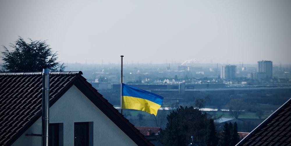 a flag on top of a building with a city in the background
