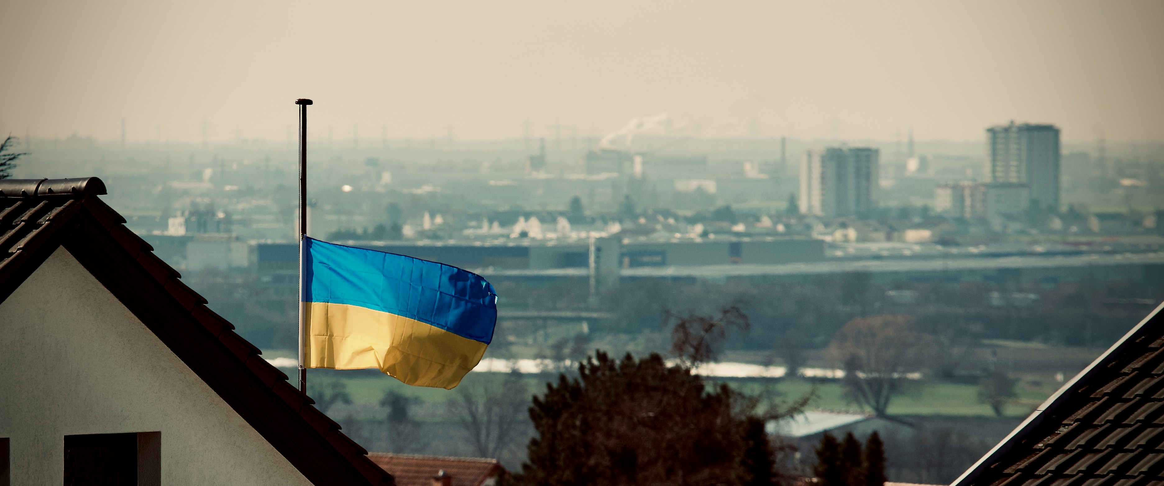 a flag flying on top of a roof in front of a city