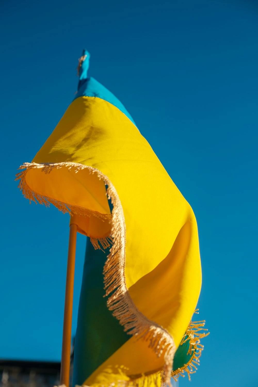 a yellow and green umbrella with a blue sky in the background