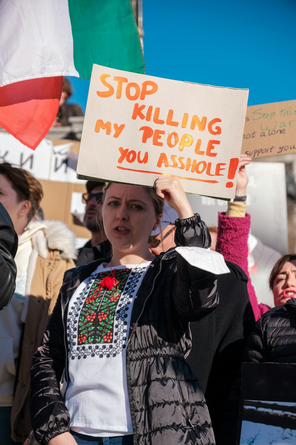 Una donna con un cartello che dice smetti di uccidere il mio popolo