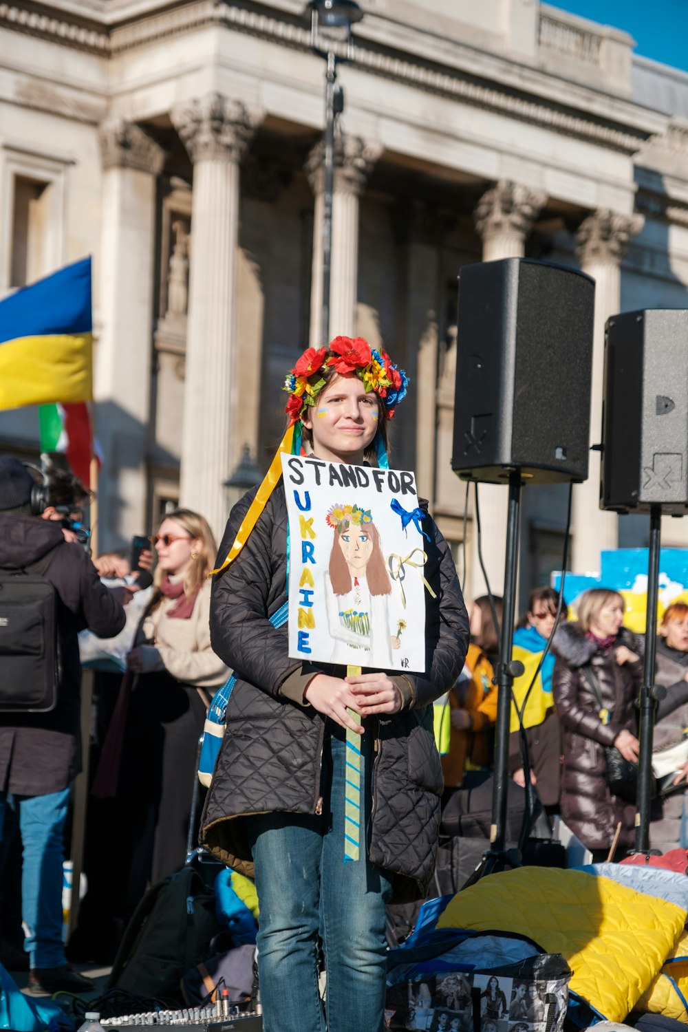 a woman holding a sign in front of a crowd