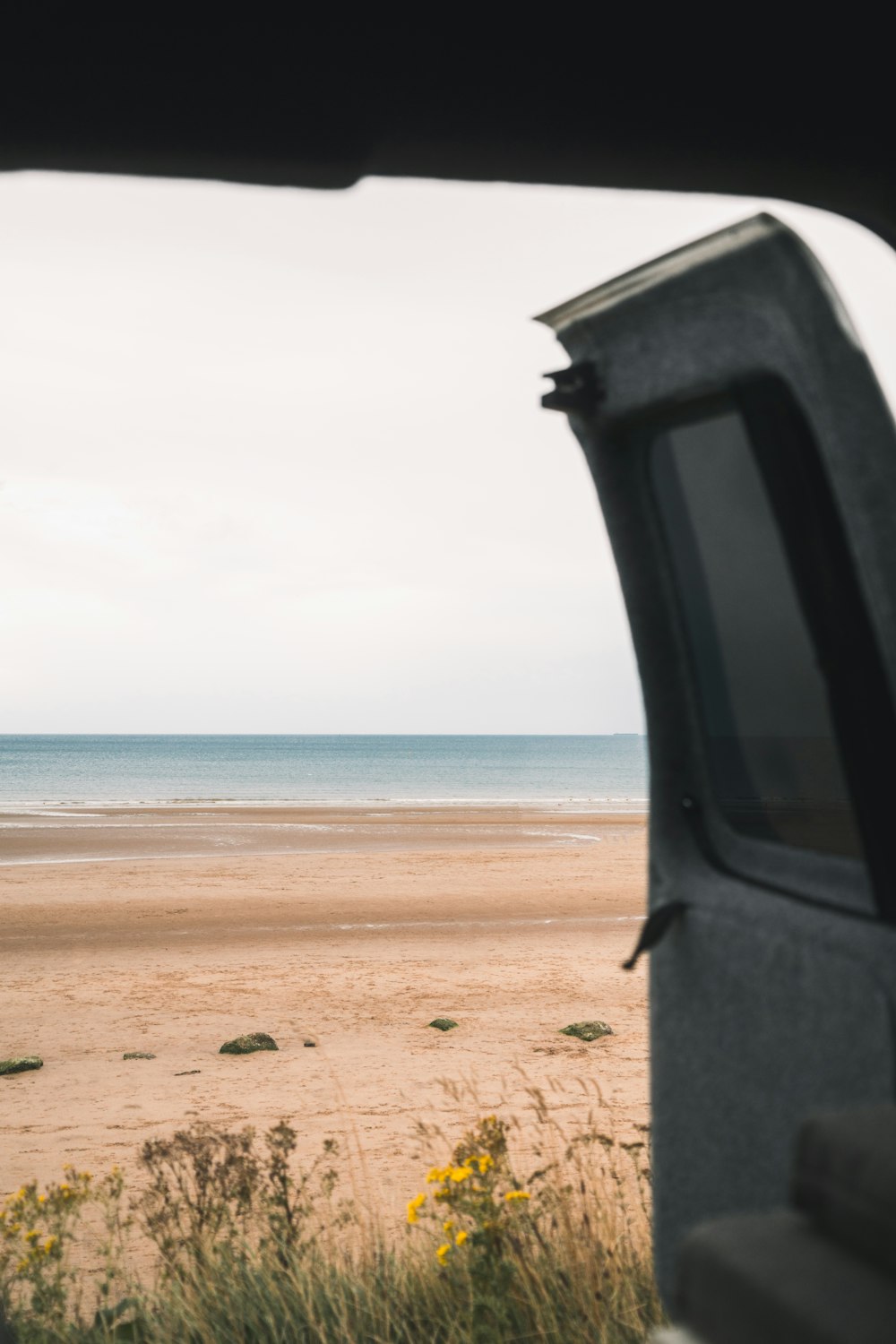 a view of a beach from inside a vehicle