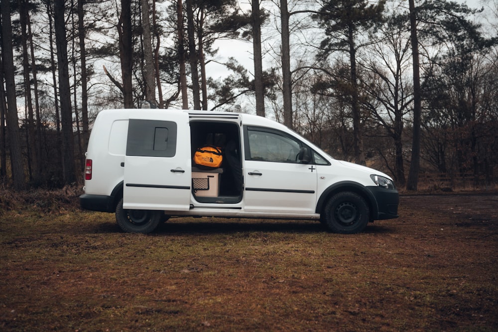 a white van parked in a wooded area