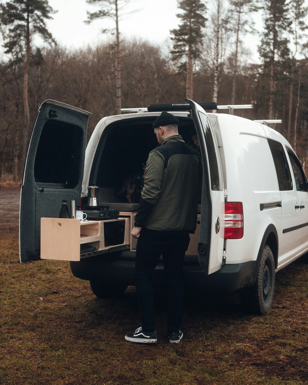 a man standing in the back of a white van