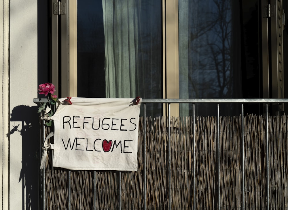 a sign that says refugees welcome on a building