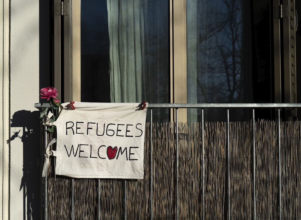 uma placa que diz que os refugiados são bem-vindos em um prédio