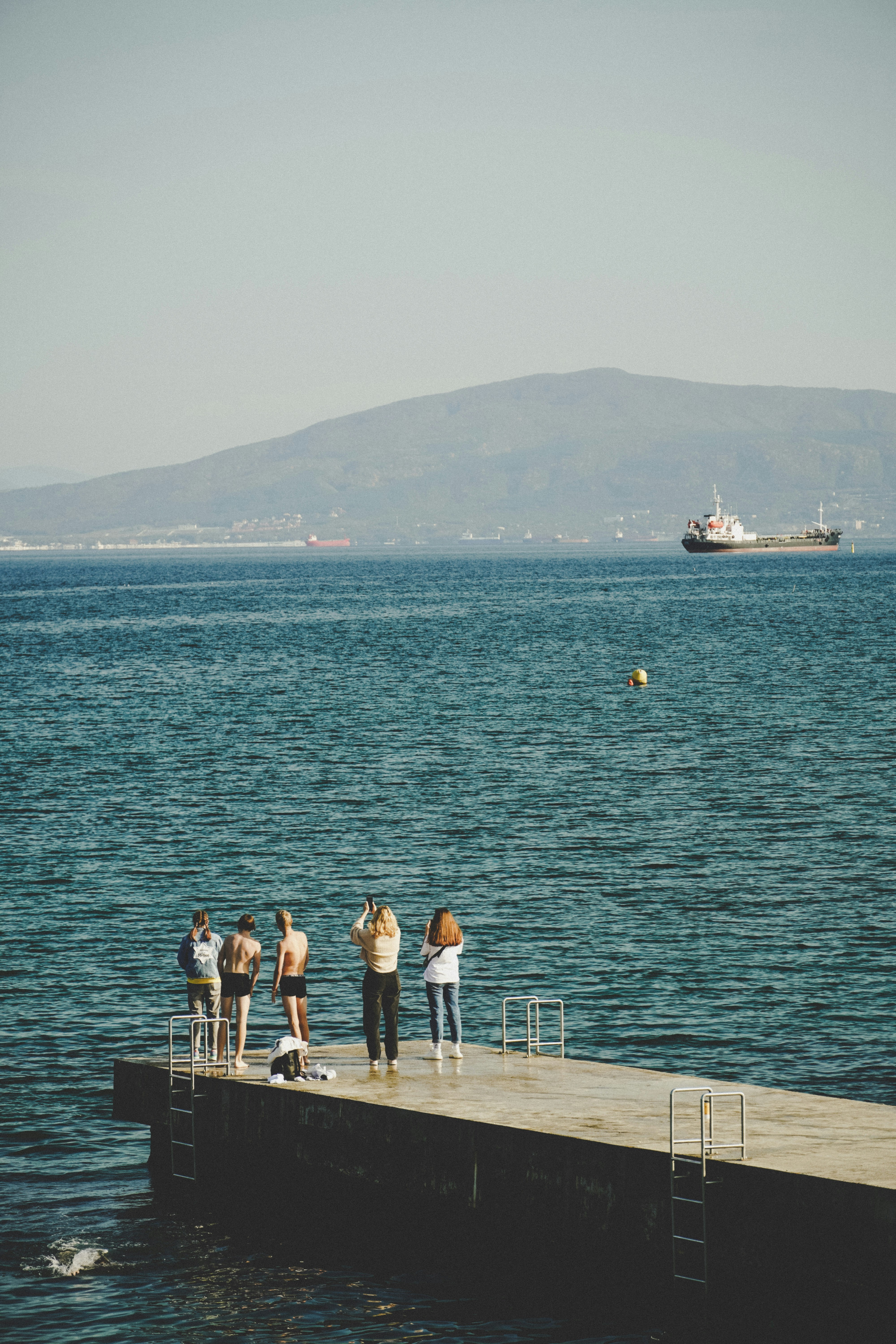 a group of people standing on top of a pier