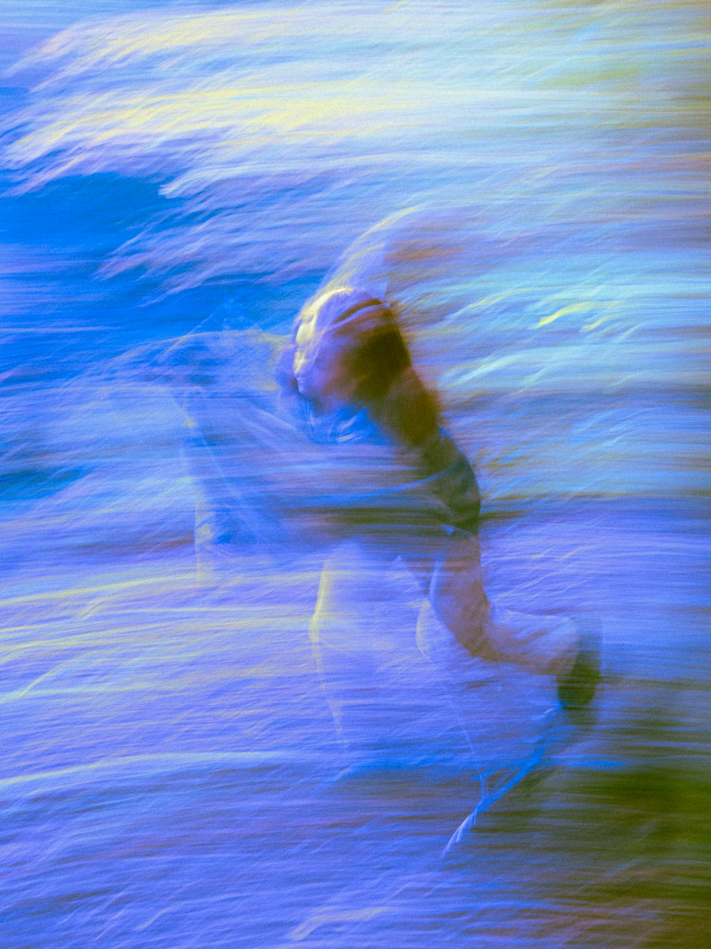 a blurry photo of a person surfing on a wave