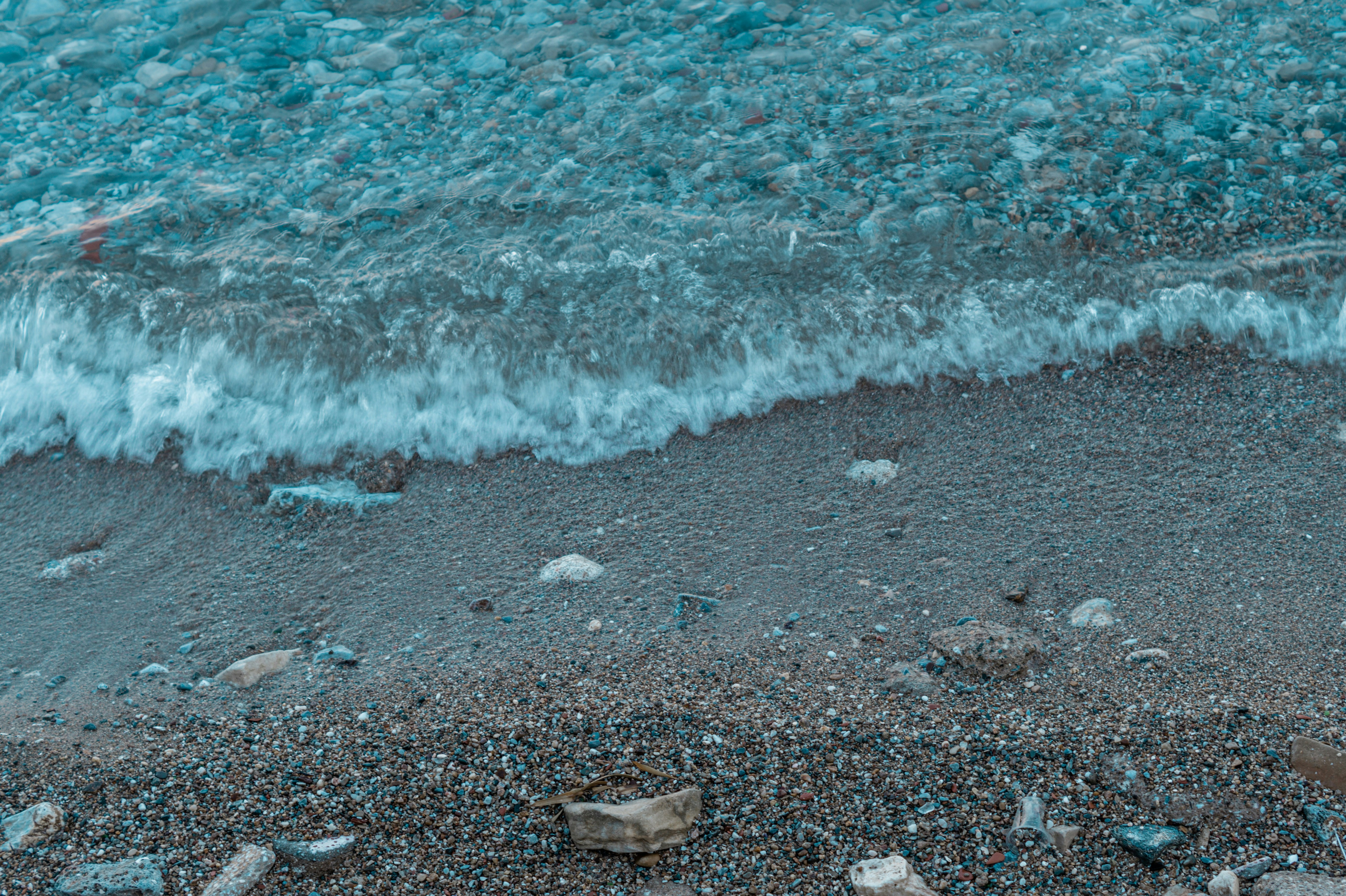 a beach with a wave coming in to the shore