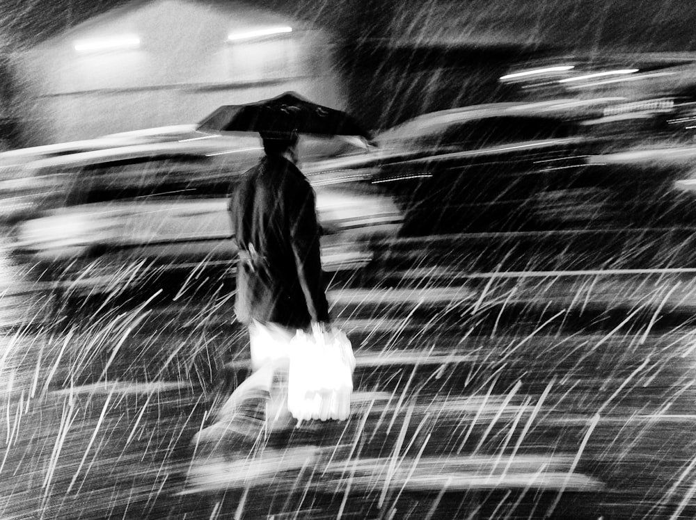 a man walking in the rain with an umbrella