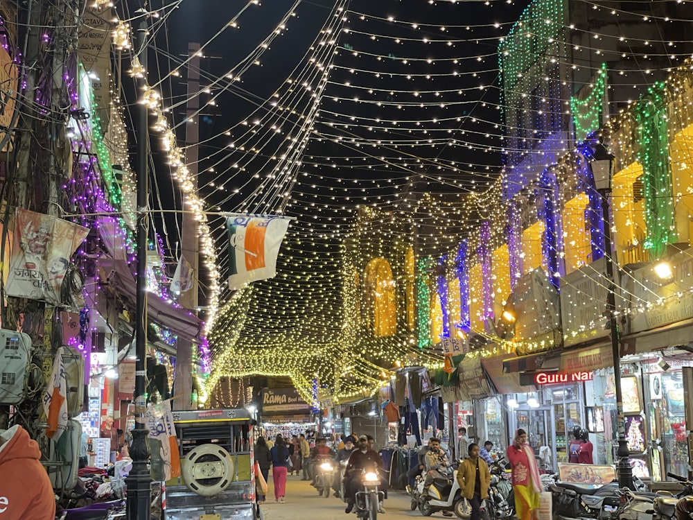 a busy city street with lots of lights strung over it