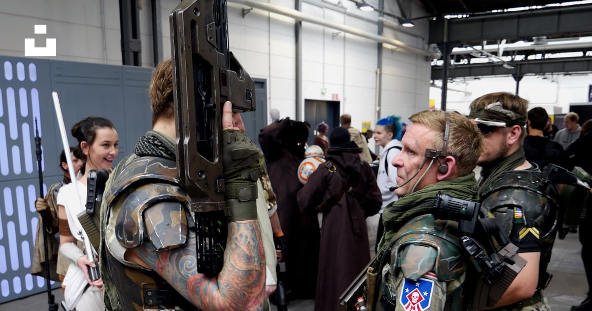 A group of people standing around each other with guns photo – Free ...