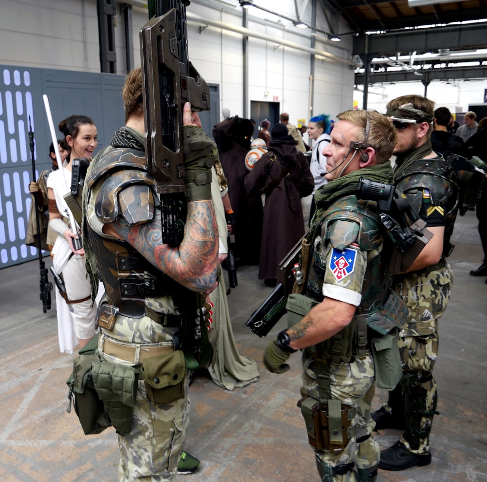 a group of people standing around each other with guns