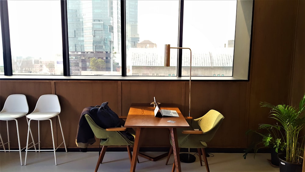 a table and chairs in a room with a view of the city