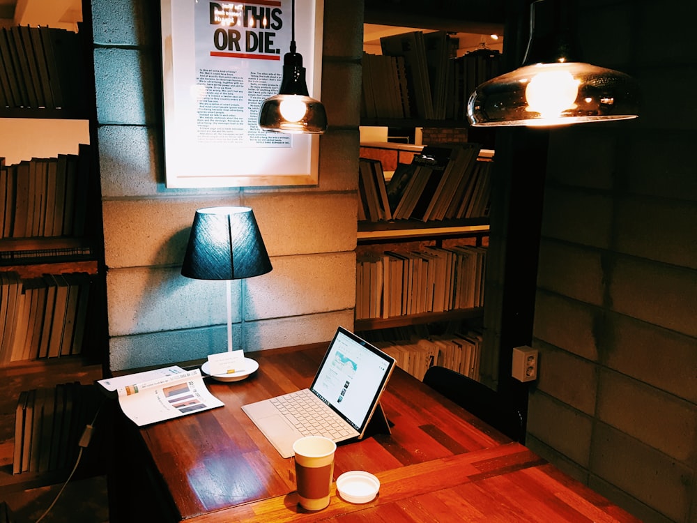 a laptop computer sitting on top of a wooden desk