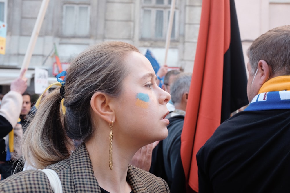 Eine Frau mit geschminktem Gesicht vor einer Menschenmenge