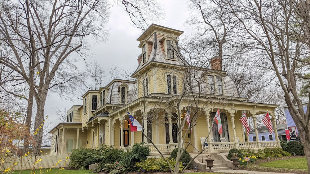 a yellow house with american flags on the front of it