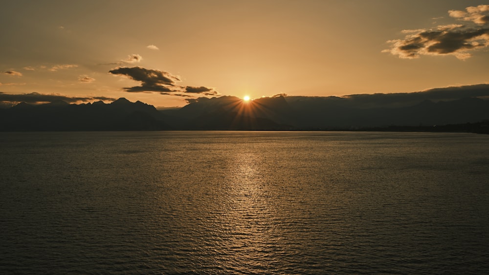 a large body of water with a sunset in the background