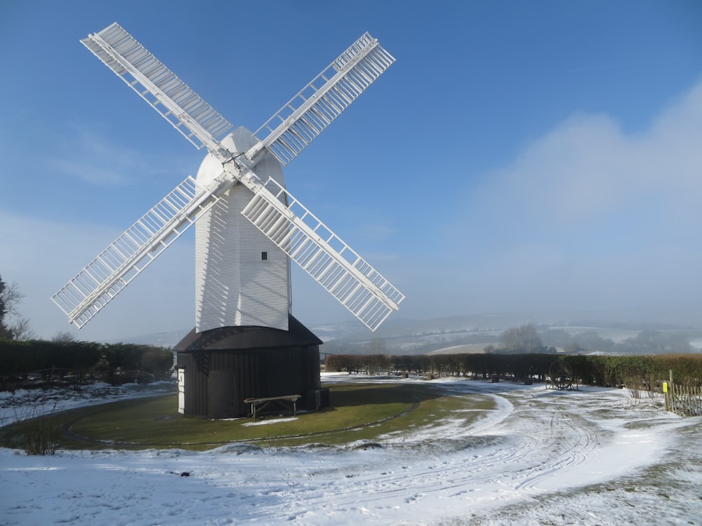 a large white windmill sitting on top of a snow covered field
