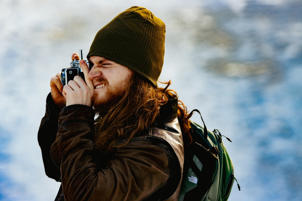 a man with long hair is holding a cell phone