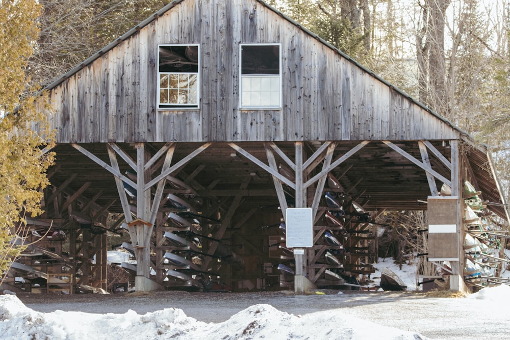 un bâtiment en bois avec un tas de neige au sol