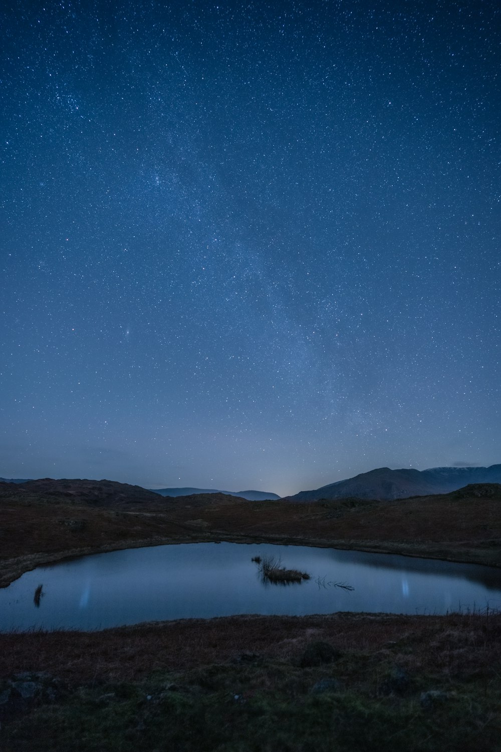 a body of water with a mountain in the sky