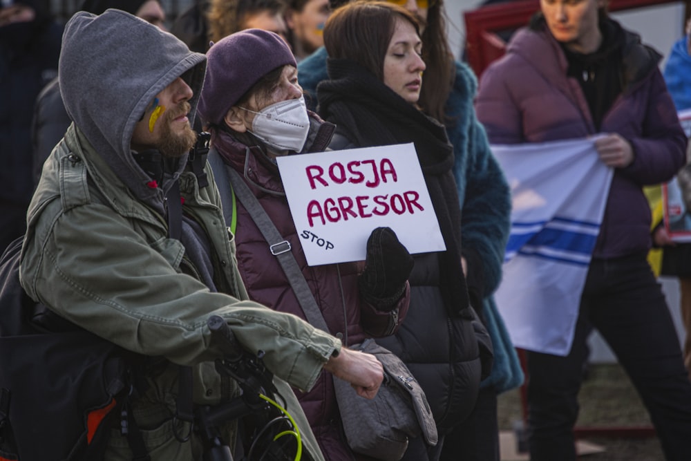 a group of people standing next to each other holding signs