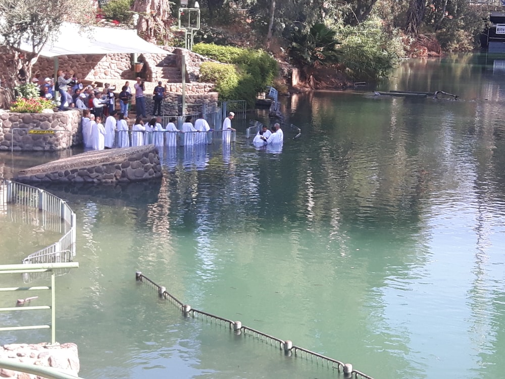 a group of people standing in the middle of a lake