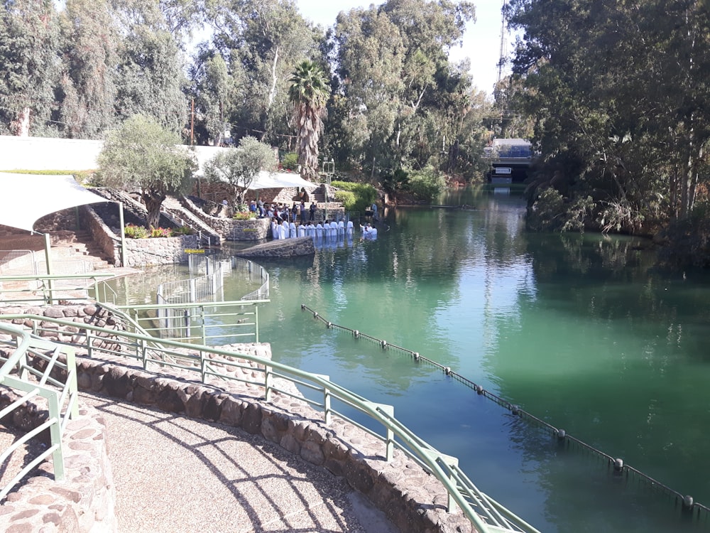 a body of water surrounded by trees and stairs