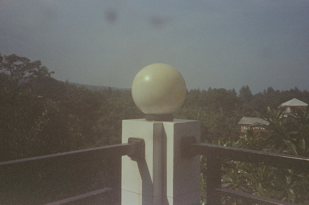 a large white ball sitting on top of a metal pole