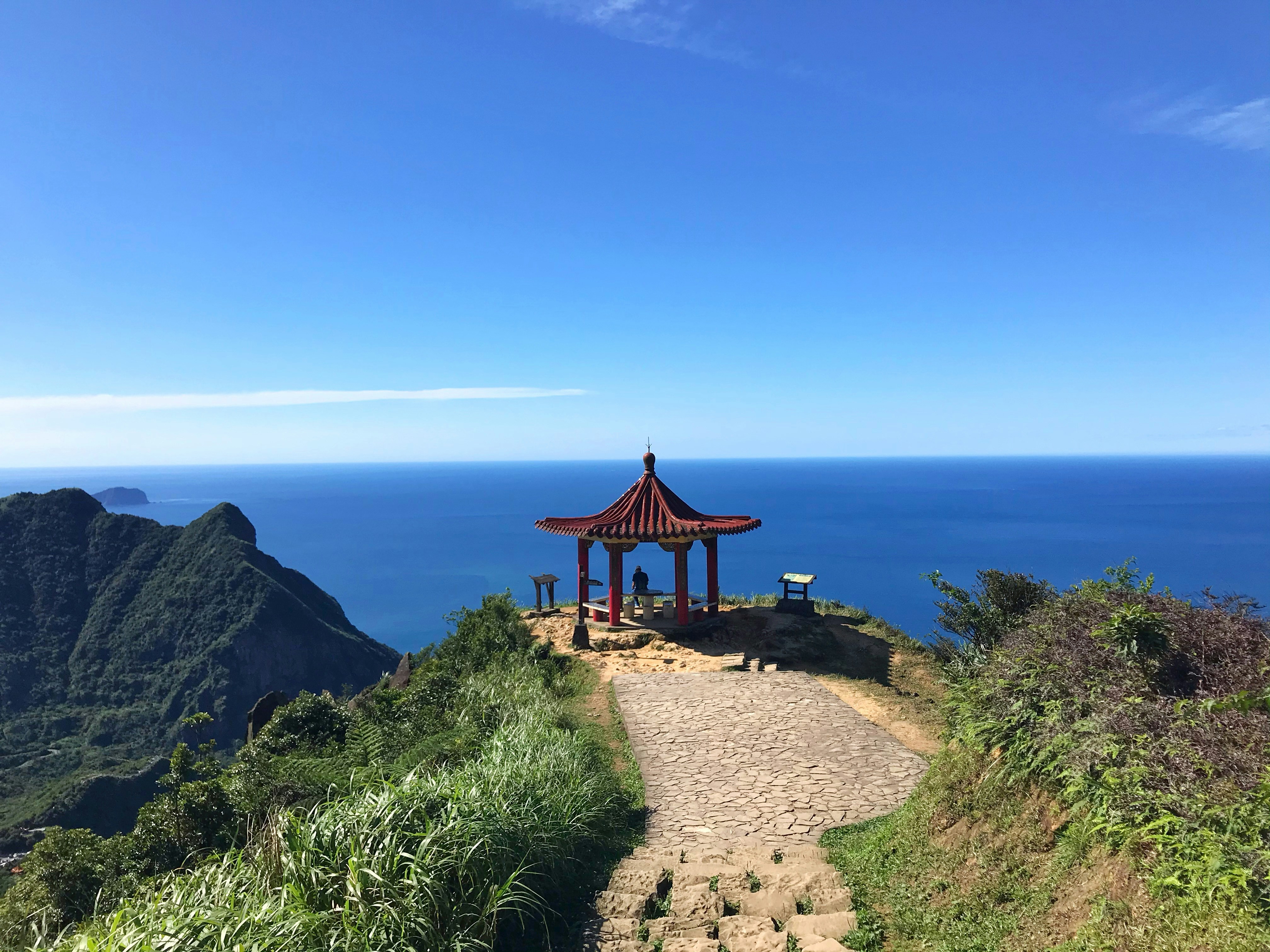 A gazebo sitting on top of a hill next to the ocean photo – Free Land ...