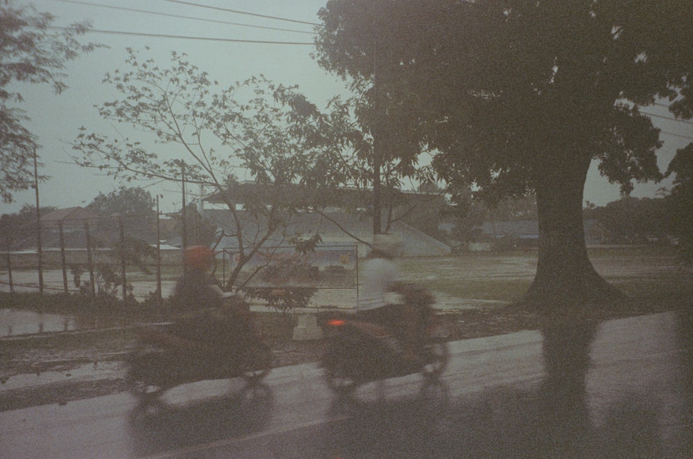 a couple of people riding motorcycles down a street