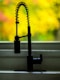 a kitchen sink with a faucet and a window in the background