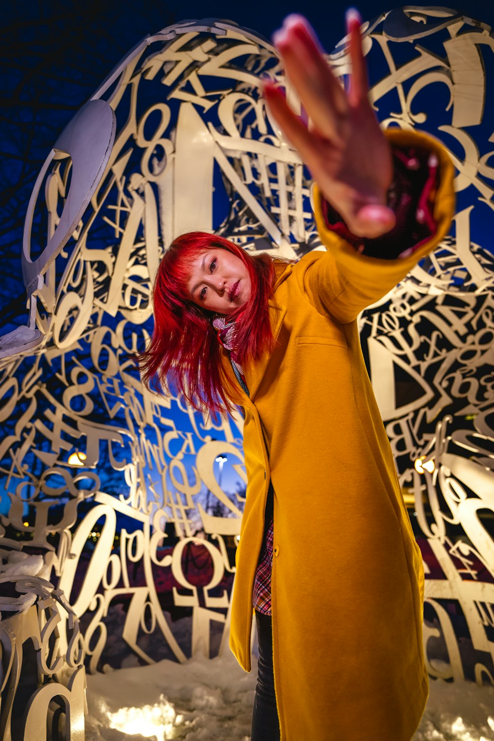 a woman standing in front of a sculpture