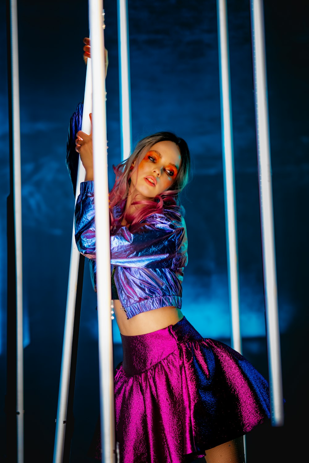 a woman in a purple outfit is holding a pole