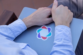 a person holding a laptop with a logo on it