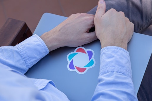 a person holding a laptop with a logo on it