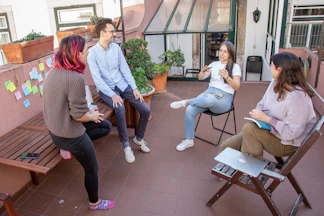 a group of people sitting around a wooden bench