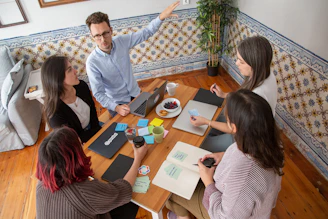 a group of people sitting around a wooden table