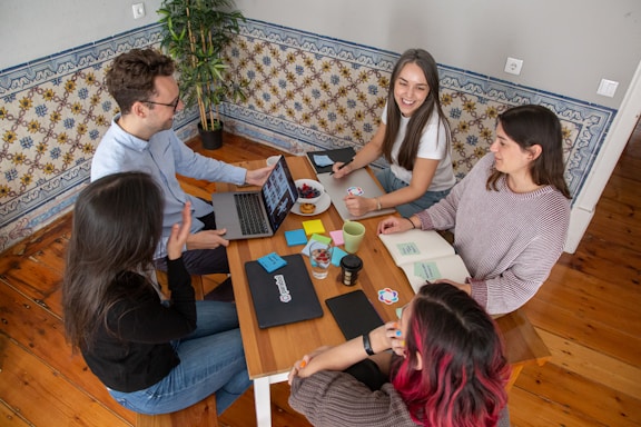 a group of people sitting around a wooden table