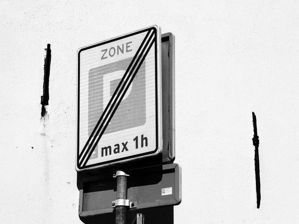 a no parking zone sign on a white wall