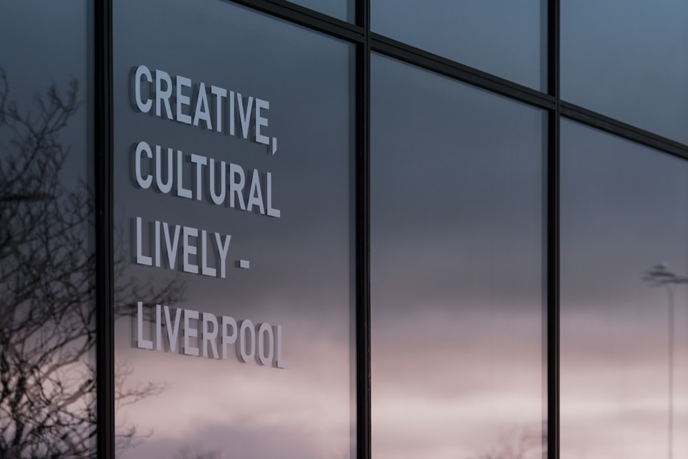 a window with a sign on it that says creative, cultural, lively, liverpool