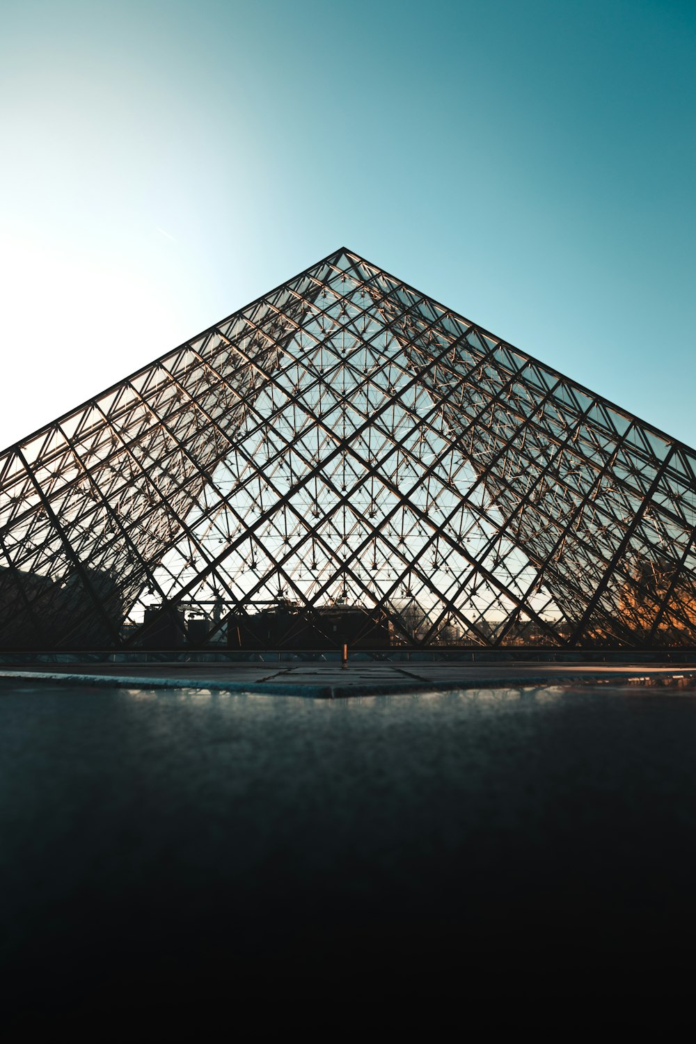 a large glass pyramid sitting in front of a building