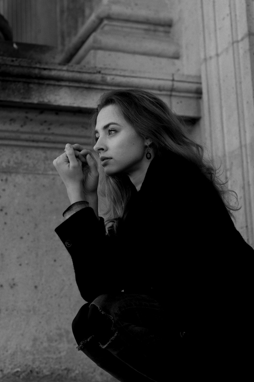 a woman sitting on the ground smoking a cigarette