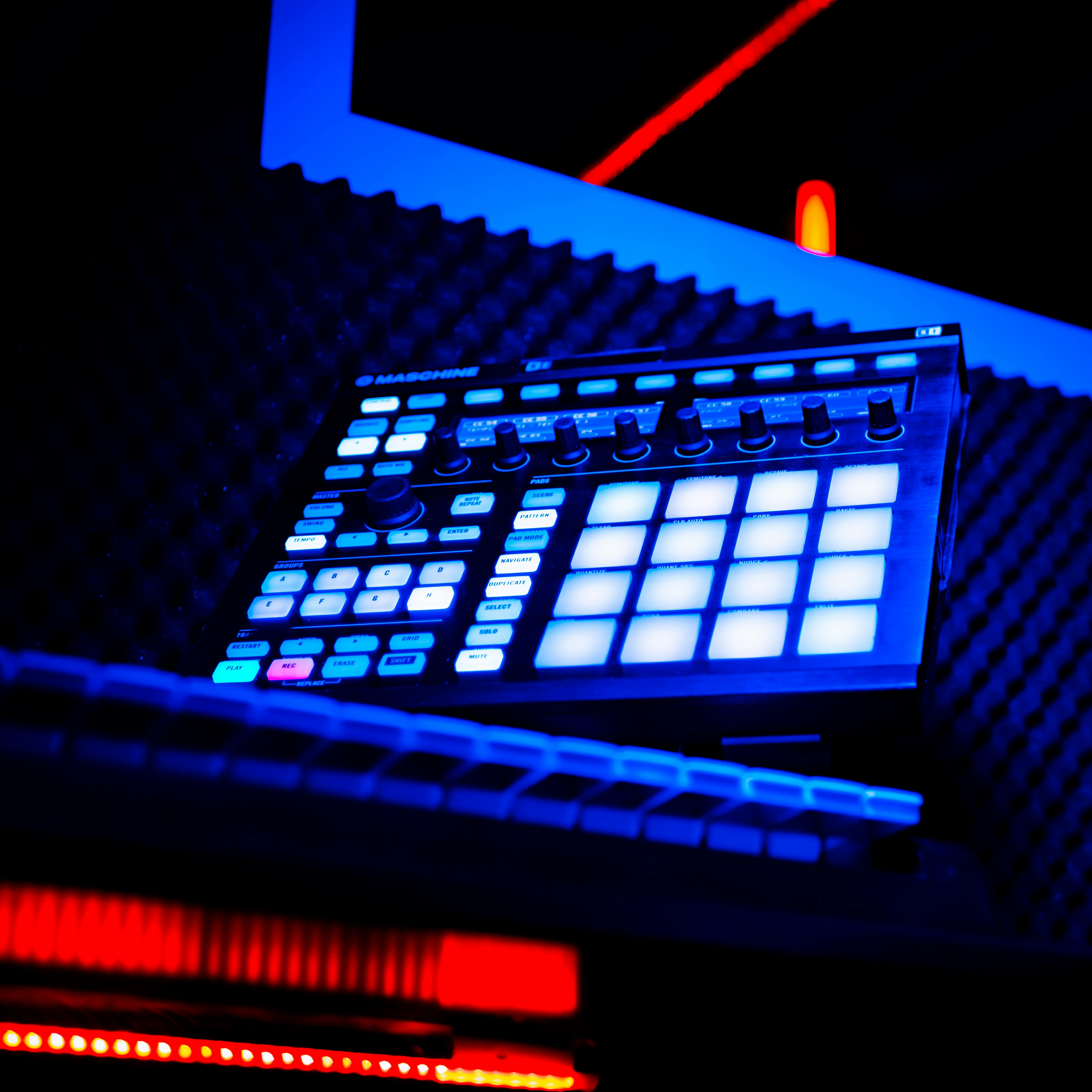 Drum Machine in a recording studio with blue and red neon lights.